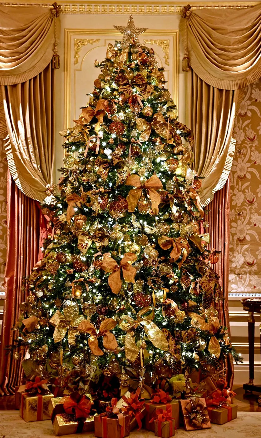 Gold and bronze decorated Christmas tree with wrapped gifts by Pulbrook & Gould