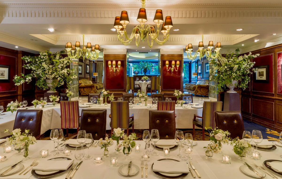 White floral arrangements in a London hotel private dining room by Pulbrook & Gould