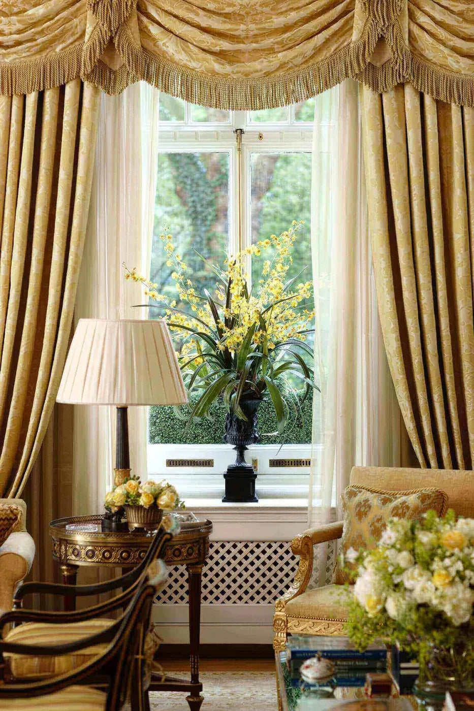 Yellow orchid arrangement in an urn by a window in a private London home by Pulbrook & Gould