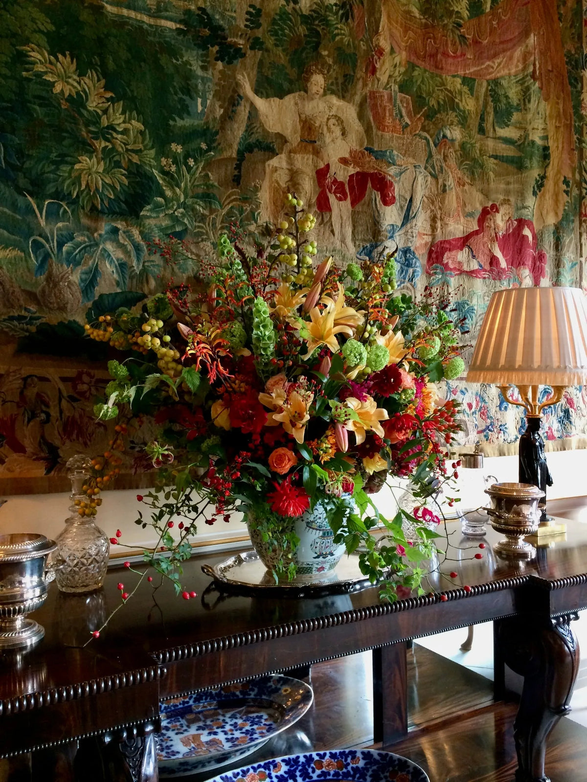 Autumnal orange and red flower arrangement in a private London home by Pulbrook & Gould