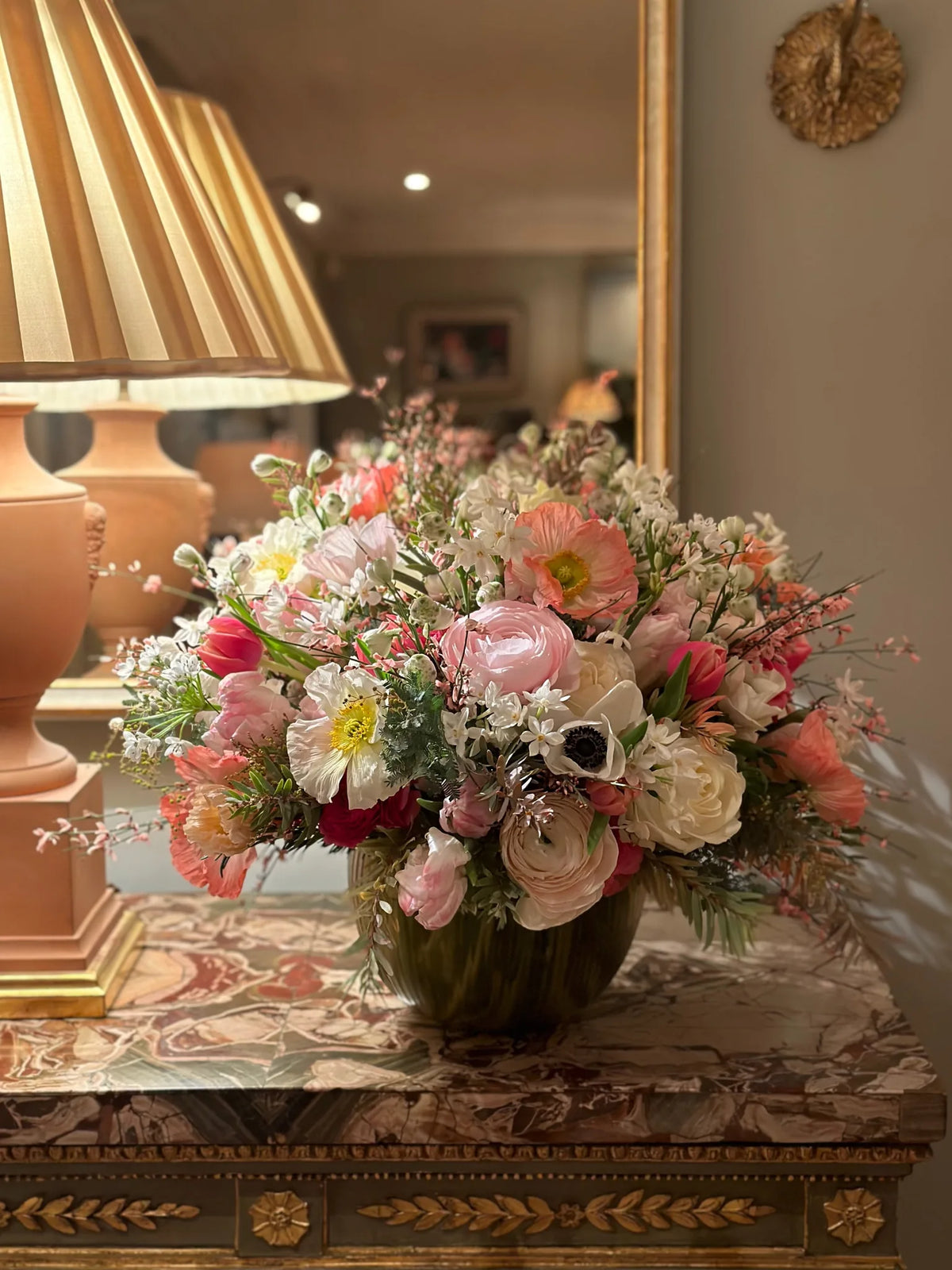 Pink and white ranunculus and anemone arrangement on a marble console table by Pulbrook & Gould