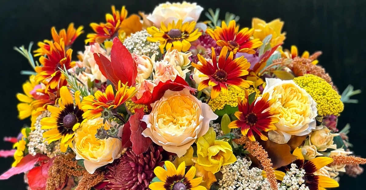 Bouquet of pink garden roses, orange ranunculus and peonies by Pulbrook & Gould