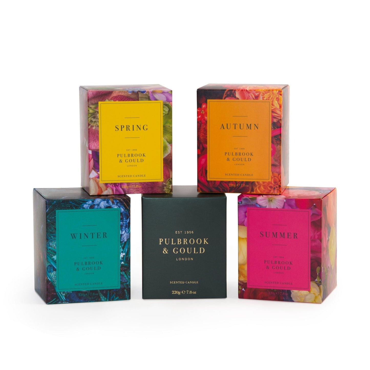A collection of five scented candles from Pulbrook & Gould, each with a different colour packaging and floral design.