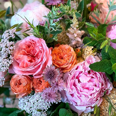 
                    
                      Summer Joy by Pulbrook Gould hand-tied bouquet with pink and orange roses, leafy foliage and astrantia accents
                    
                  
