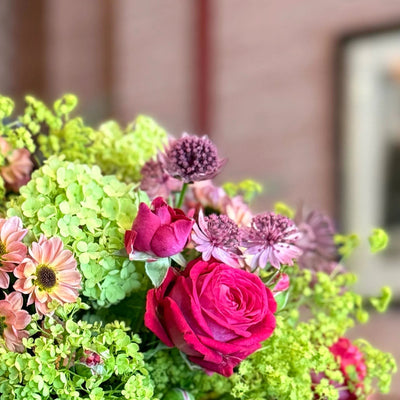 
                    
                      Summer Sparklings Posy by Pulbrook and Gould hand-tied posy bouquet with bright pink roses and green foliage
                    
                  