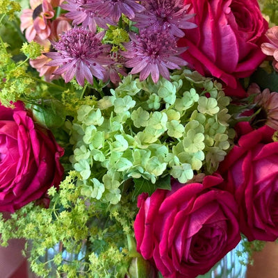 
                    
                      Summer Thrills Posy by Pulbrook and Gould fresh-cut floral posy bouquet with purple clematis and pink roses
                    
                  