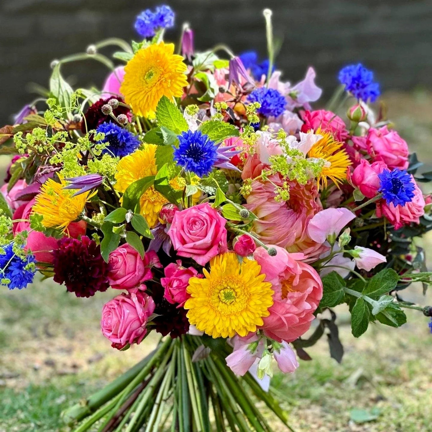Summer Vibrations Pulbrook and Gould hand tied bouquet in bright pink, yellow and blue with mixed summer blooms