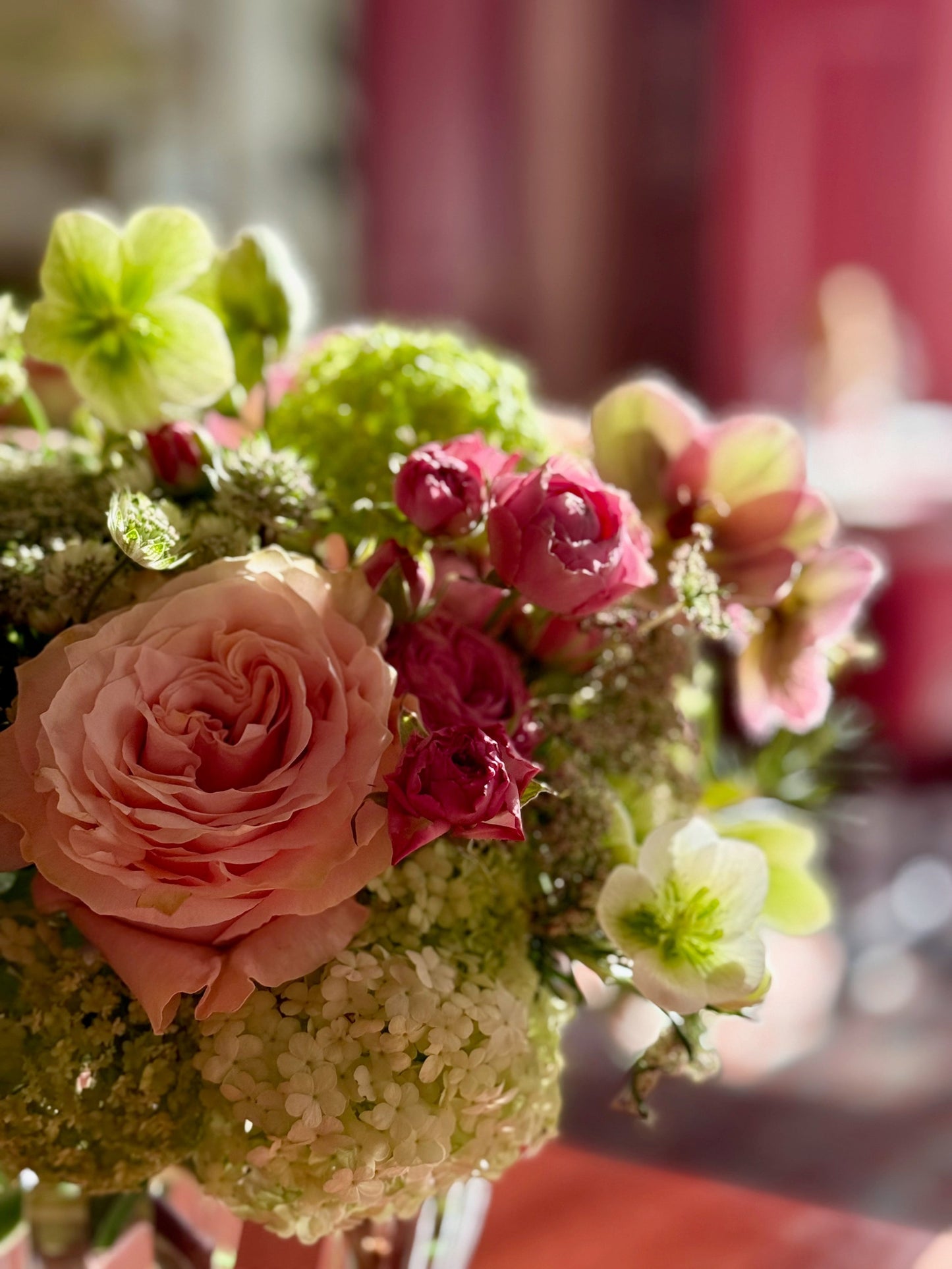 Close-up of a floral arrangement with pink and green flowers.