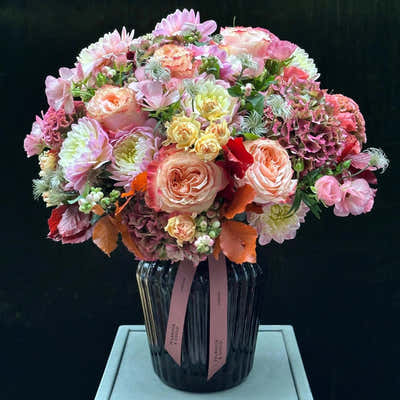 
                    
                      The Beaufort by Pulbrook and Gould hand-tied bouquet and vase arrangement in pink and cream with autumn foliage
                    
                  