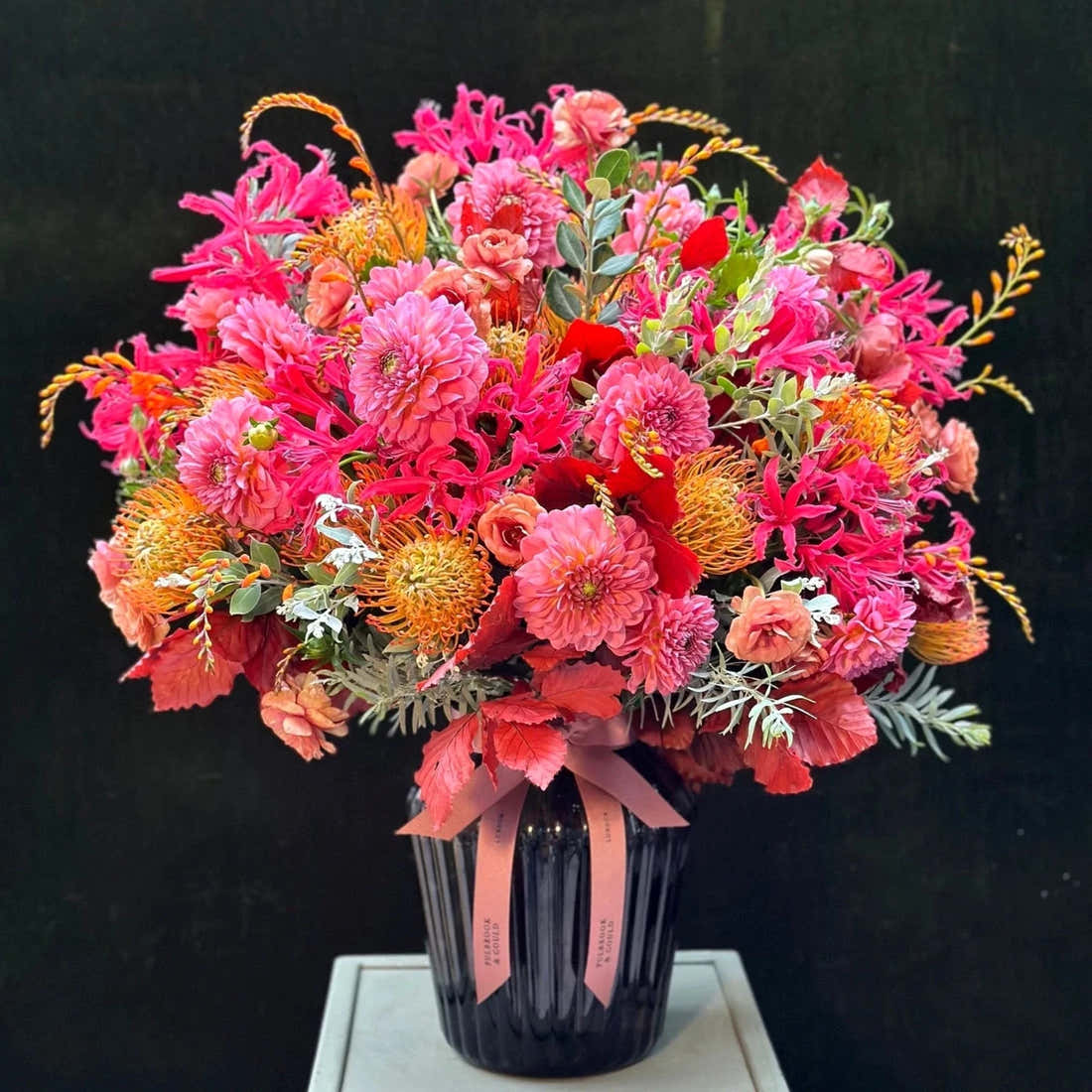 The Rutland by Pulbrook and Gould hand tied bouquet and vase arrangement in pink, orange and red autumn blooms