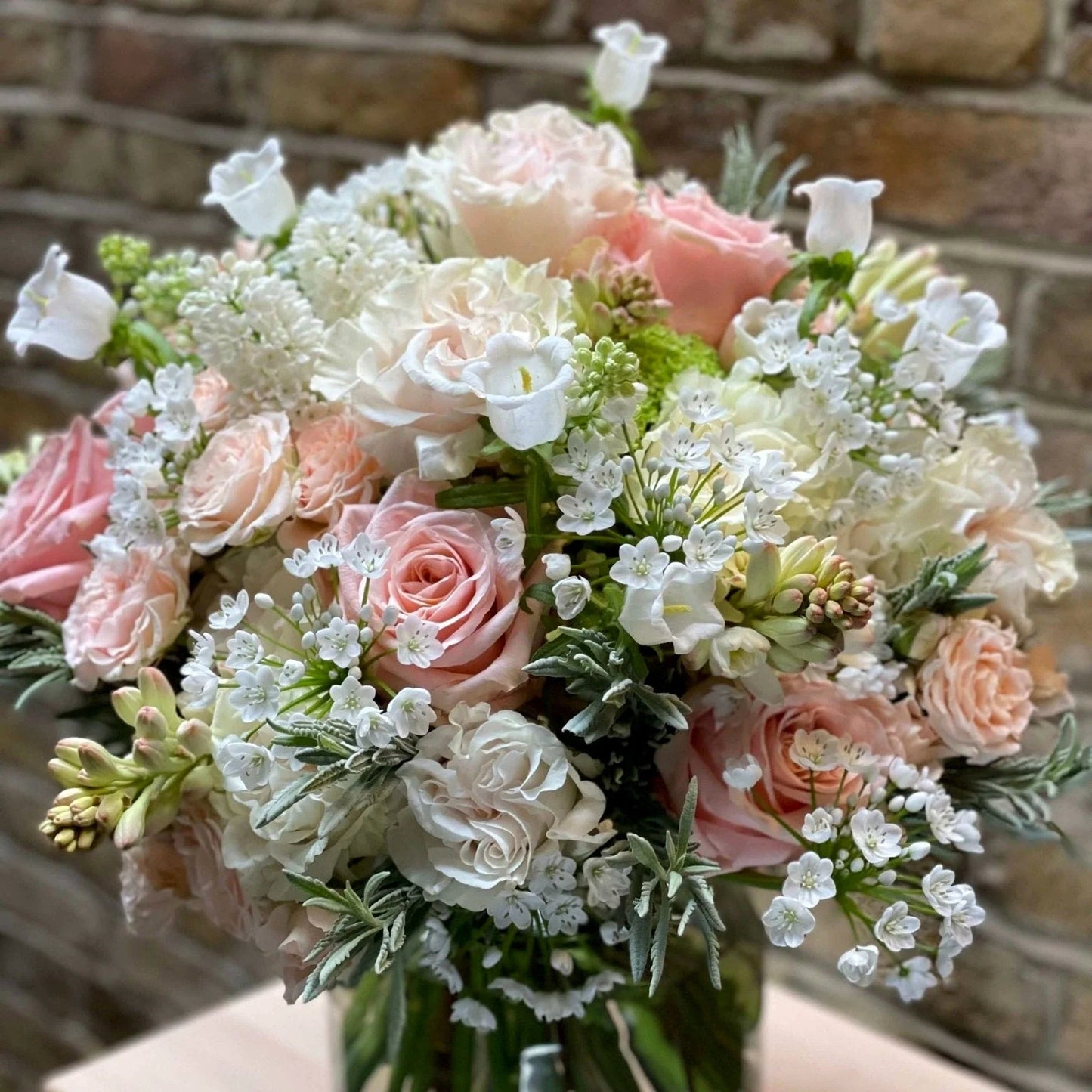 Victoria Pulbrook and Gould hand tied bouquet in pastel pink and white with fresh roses and lilac flowers