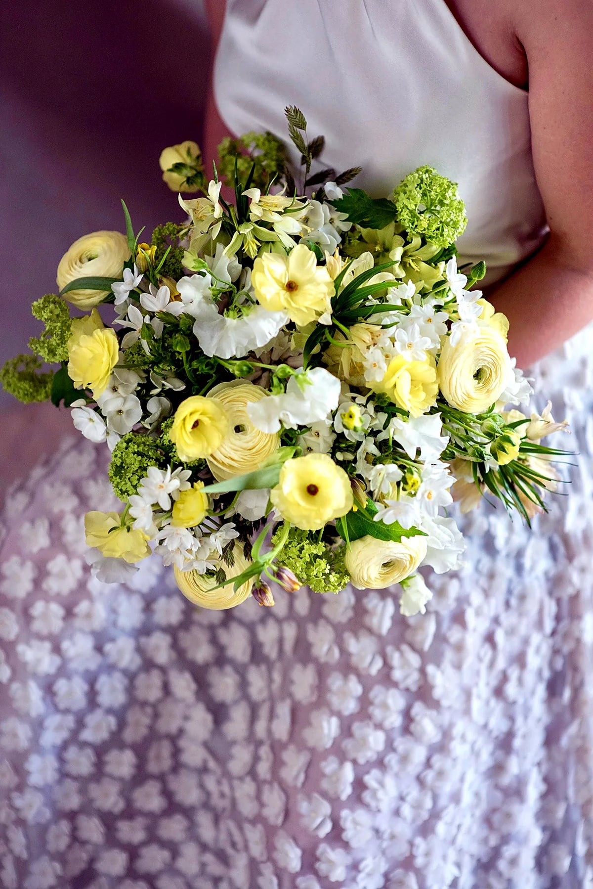Bridal bouquet of yellow ranunculus, roses and white stocks by Pulbrook & Gould