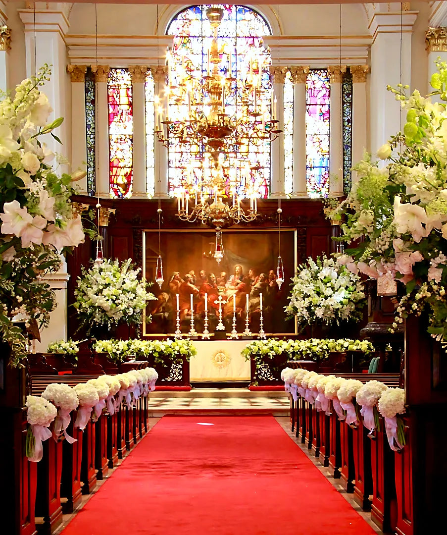 White flower arrangements and pew ends at a London church wedding ceremony by Pulbrook & Gould