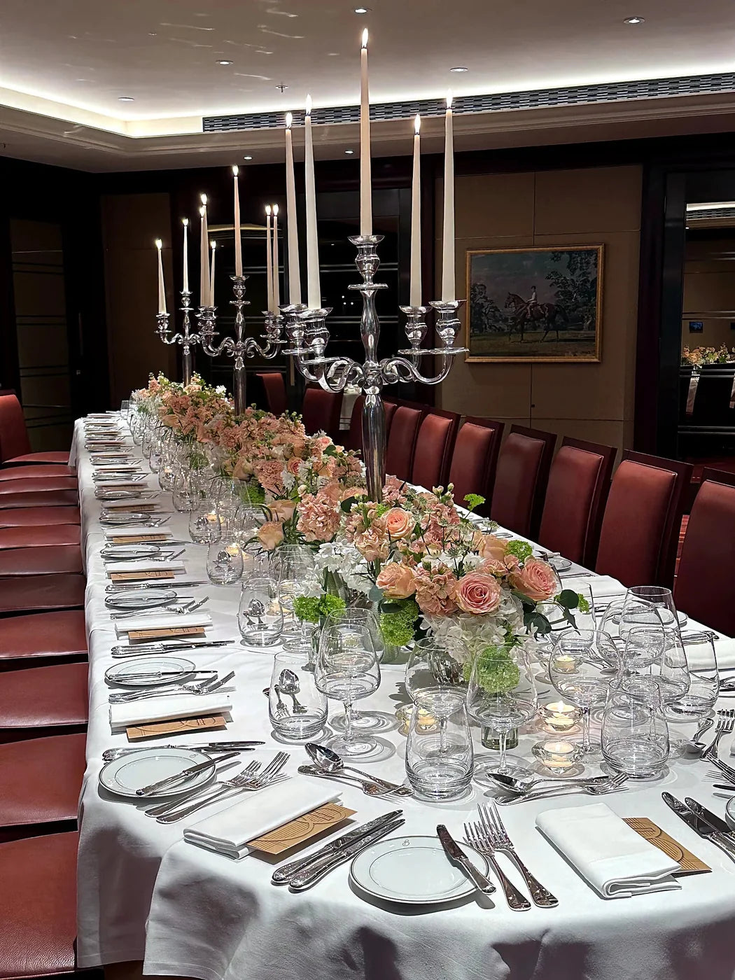 Silver candelabra and pink floral table runner at a wedding reception dinner by Pulbrook & Gould