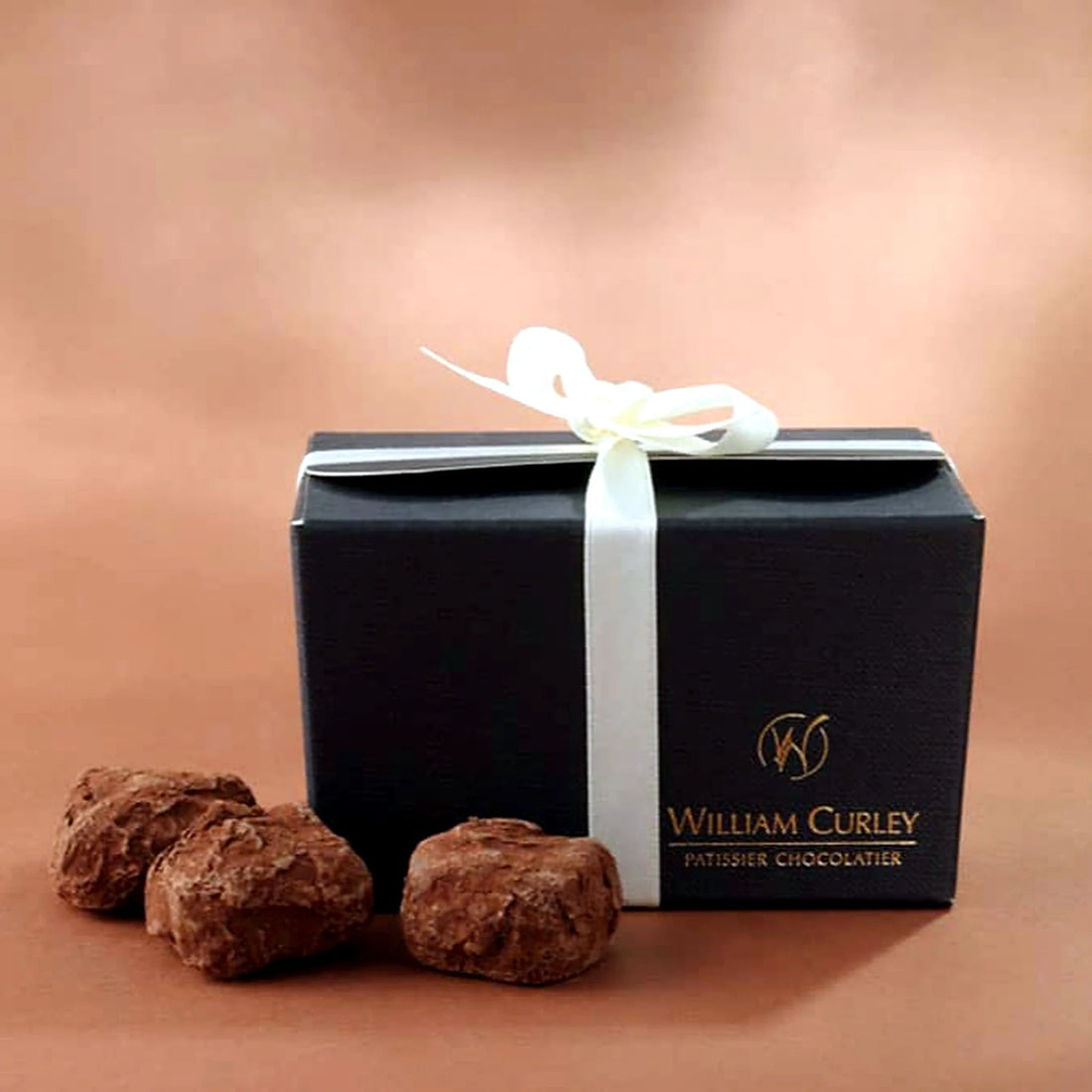 William Curley Milk Truffles by Pulbrook and Gould, milk chocolate truffles in a black gift box tied with ribbon